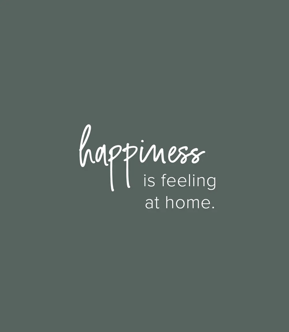 Minimalistisches Design-Zitat auf grau-grünem Hintergrund mit handschriftlichem Text: happiness is feeling at home.